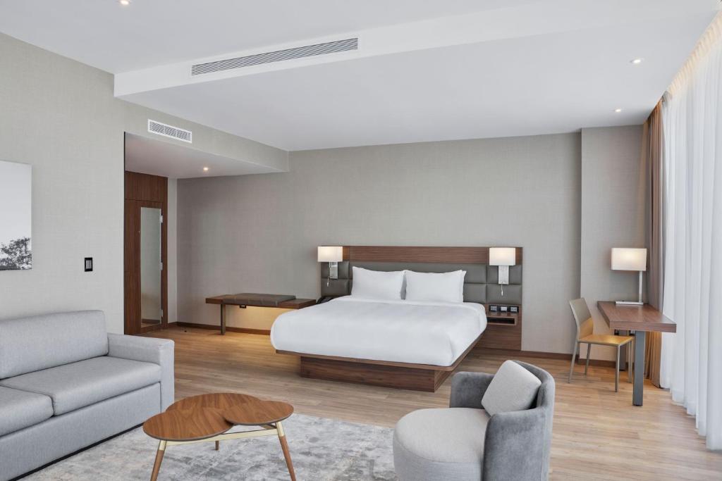 une chambre d'hôtel avec un lit et un canapé dans l'établissement AC Hotel by Marriott Saltillo, à Saltillo