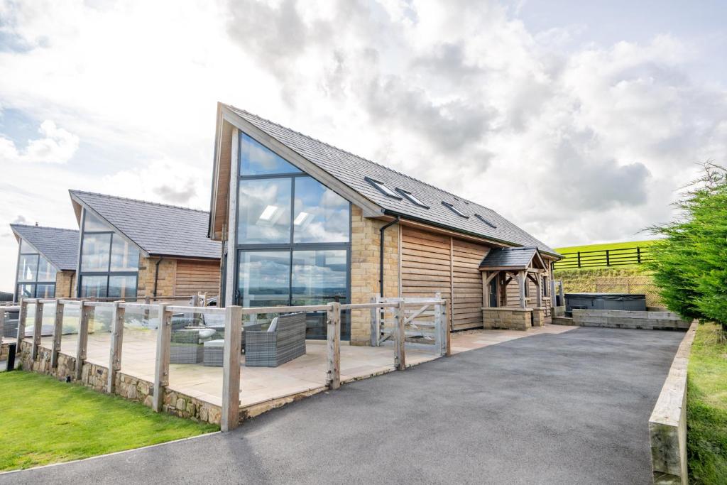 a house with a large glass window on a driveway at Pendle View by Valley View Lodges in Longridge