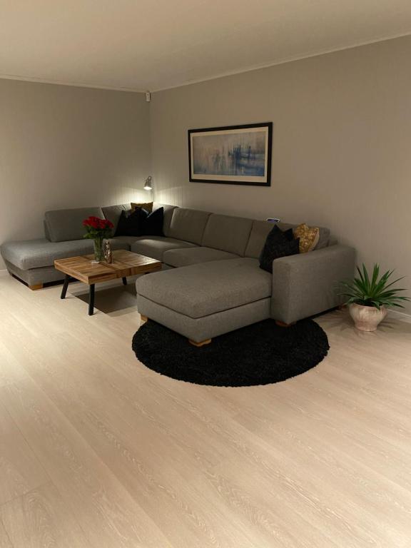 a living room with a couch and a table at Privat hjem i Grimstad - Nær Arendal og Dyreparken in Grimstad