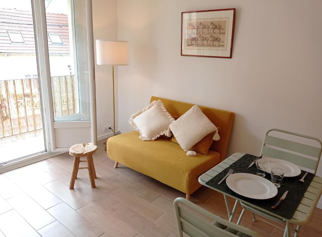 een woonkamer met een gele bank en een tafel bij Appartement de charme à Digoin in Digoin