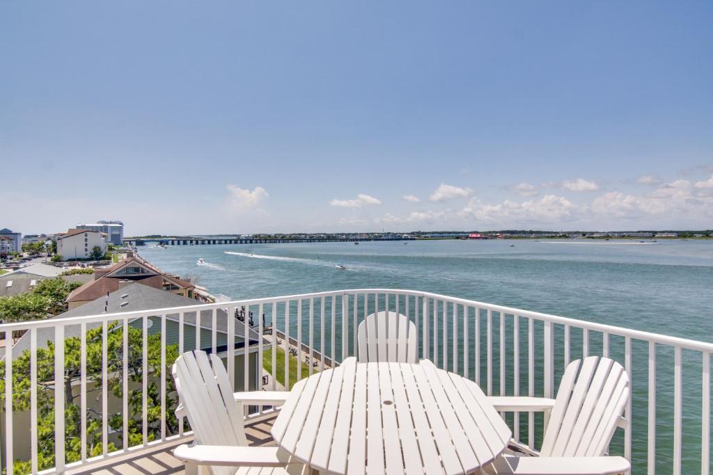 a balcony with a table and chairs and the ocean at Ocean City Condo with Panoramic Views Walk to Beach in Ocean City