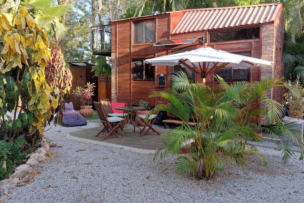 a patio with an umbrella and a table and chairs at Tiny House Villa... in Santa Cruz