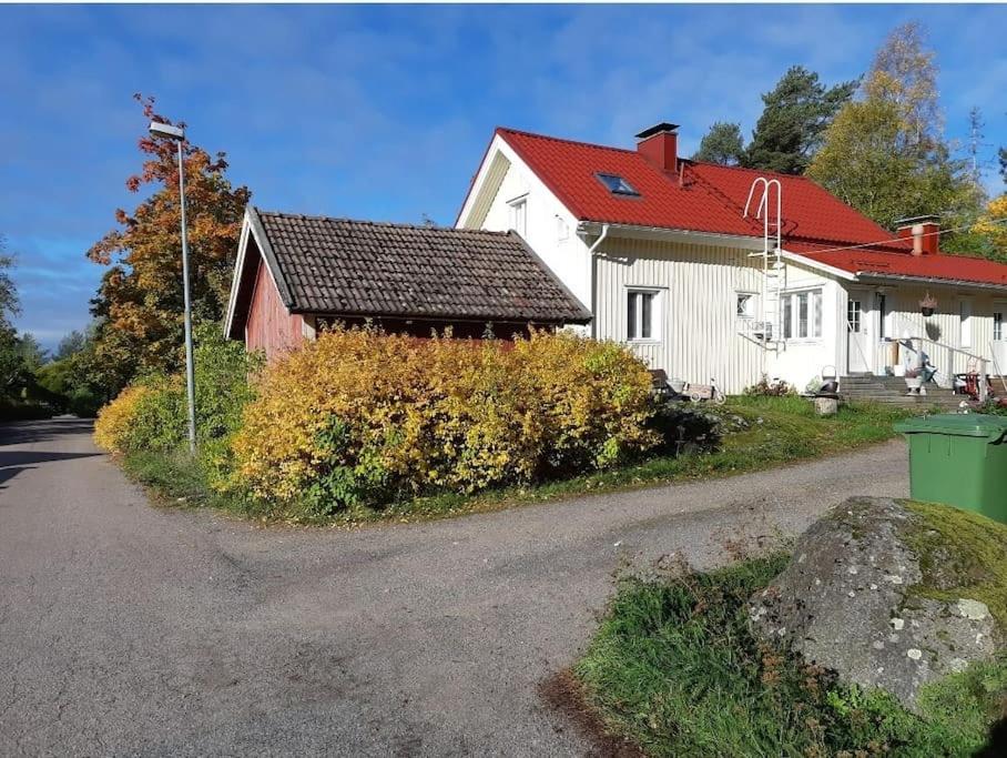 una casa blanca con techo rojo en una carretera en Yö Vaahteramäellä 