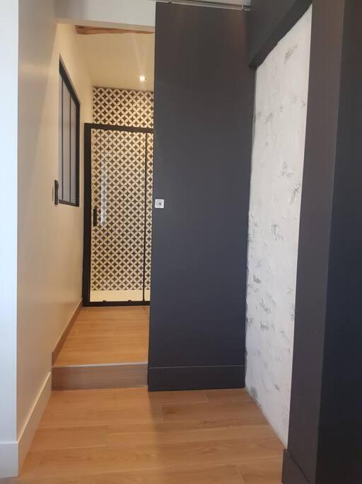 - un couloir avec un mur noir et du parquet dans l'établissement Le Merlane - A 2 pas de la Cité & du centre ville, à Carcassonne