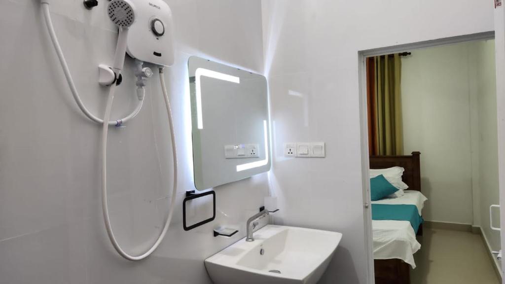 a bathroom with a sink and a mirror at Calm Guest in Trincomalee