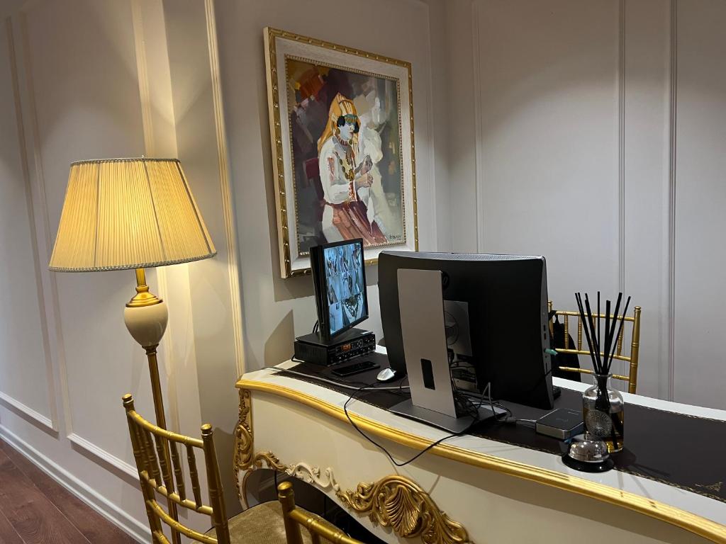 einen Schreibtisch mit einem Computer und einer Lampe in der Unterkunft SOL INVICTUS Boutique Hotel Durres Albania in Durrës