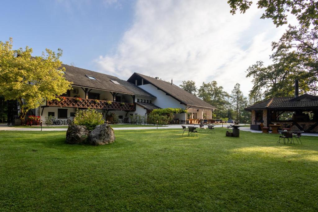 un grand bâtiment avec une cour en gazon devant lui dans l'établissement Penzion Pibernik, à Bled