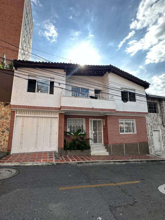 ein Haus auf einer Straße mit der Sonne dahinter in der Unterkunft Gaston2 in Medellín
