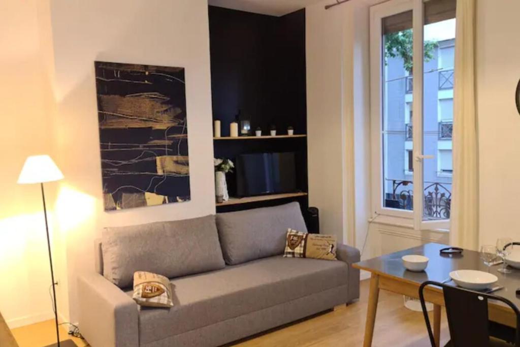 a living room with a couch and a table at Le petit Faure - Appartement 4 pers - Part-Dieu in Lyon