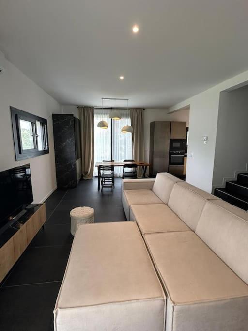 a living room with a white couch and a kitchen at Villetta bifamiliare Jesolo in Jesolo