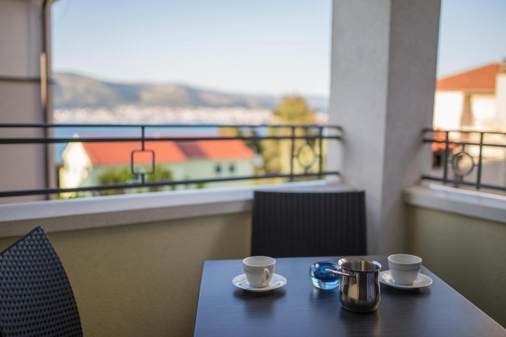 una mesa con 2 tazas de café en el balcón en Apartments Villa Novak 1, en Okrug Donji
