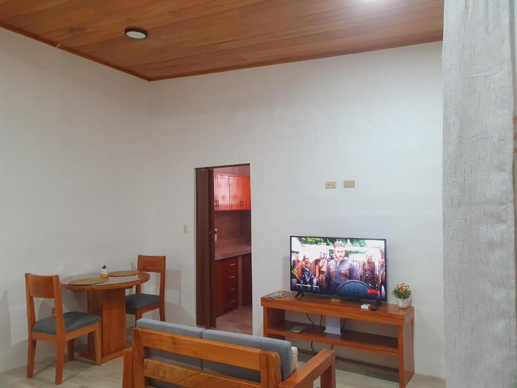 un soggiorno con TV e tavolo con sedie di Suite amoblada en Santa Cruz a Puerto Ayora