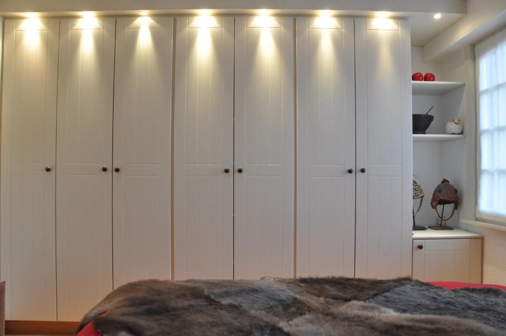 a bedroom with white cabinets with lights on them at Vakantiehuis 't Verloren Schaap Damme in Damme