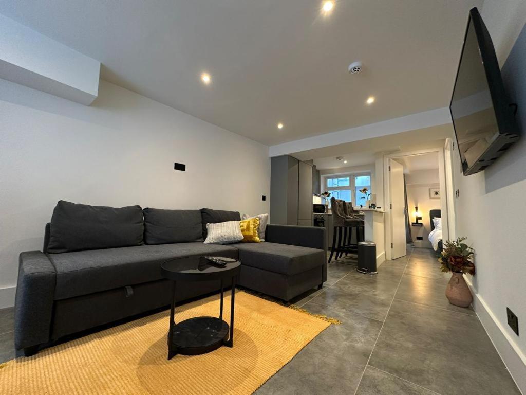 a living room with a couch and a table at Two Bedroom House In Kilburn in London