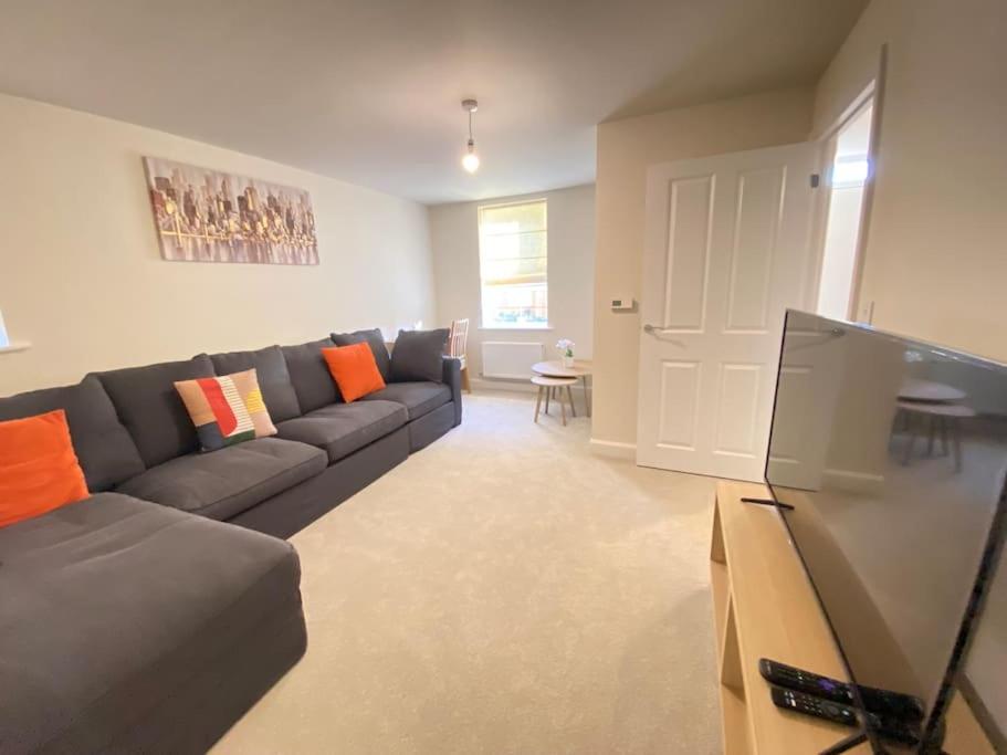a living room with a couch and a flat screen tv at Brand New Stylish 3 Bed House in Milton Keynes