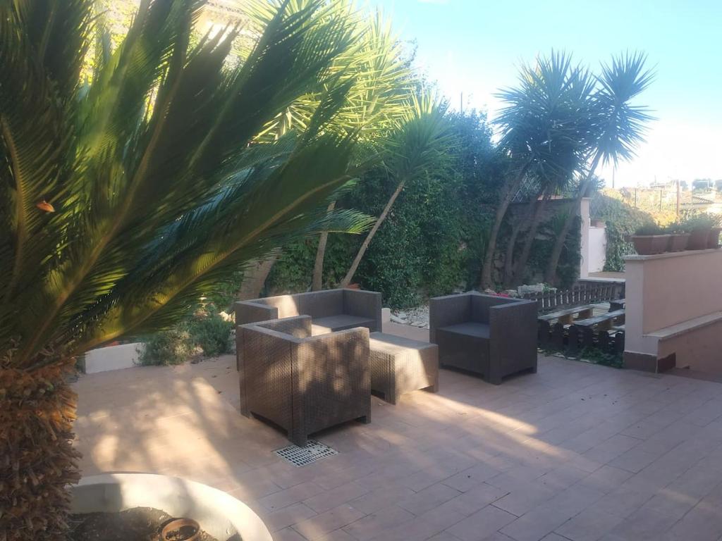 un patio avec des bancs et des palmiers dans un bâtiment dans l'établissement Relax a Marco Simone -Casa Domitilla -, à Marco Simone