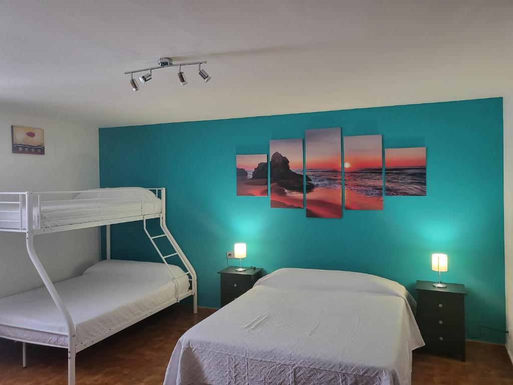 - une chambre avec 2 lits superposés et un mur bleu dans l'établissement VT y HT arrizabalaga rural montaña, à Bermeo