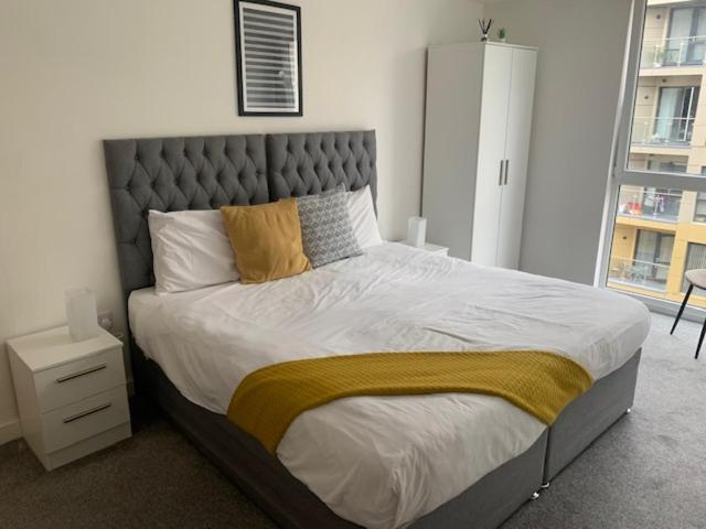 a large bed in a bedroom with a large window at Beautiful Manchester 2 bedroom apartment in Manchester