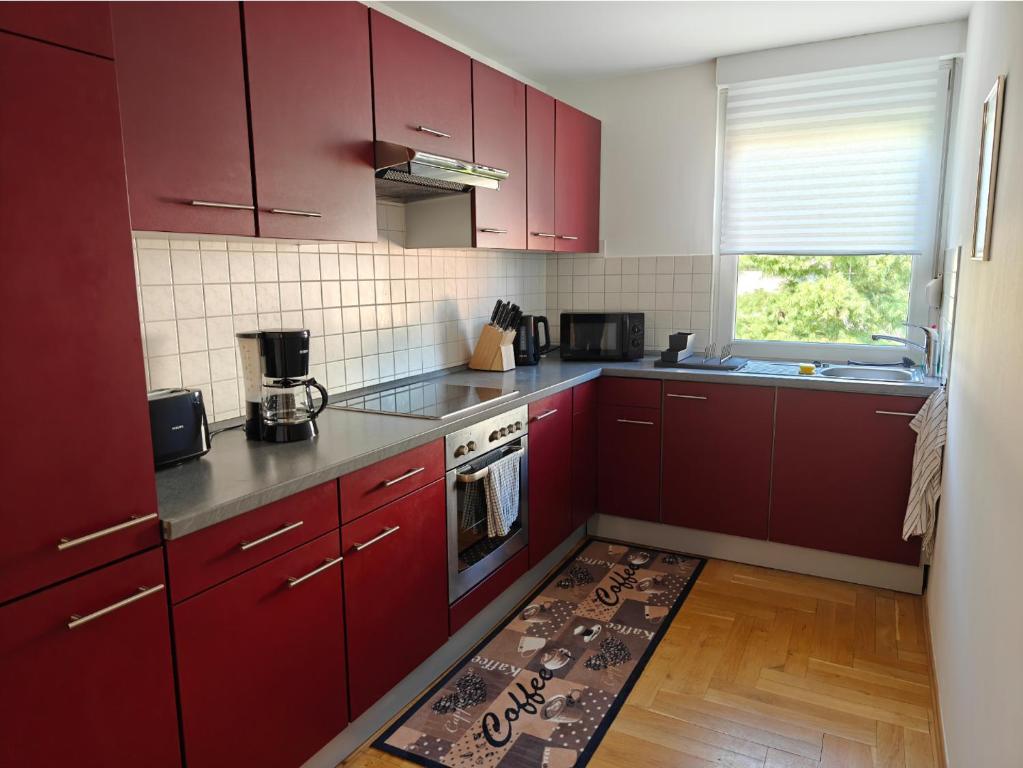 cocina con armarios rojos y alfombra de cocina en el suelo en 2BR Apartment, Parking, Wi-Fi, TV in Berlin Karow, en Berlín