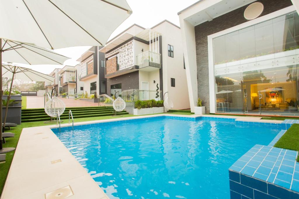 a swimming pool in front of a house at Kumasi Luxury Apartments @ The Fairview in Kumasi