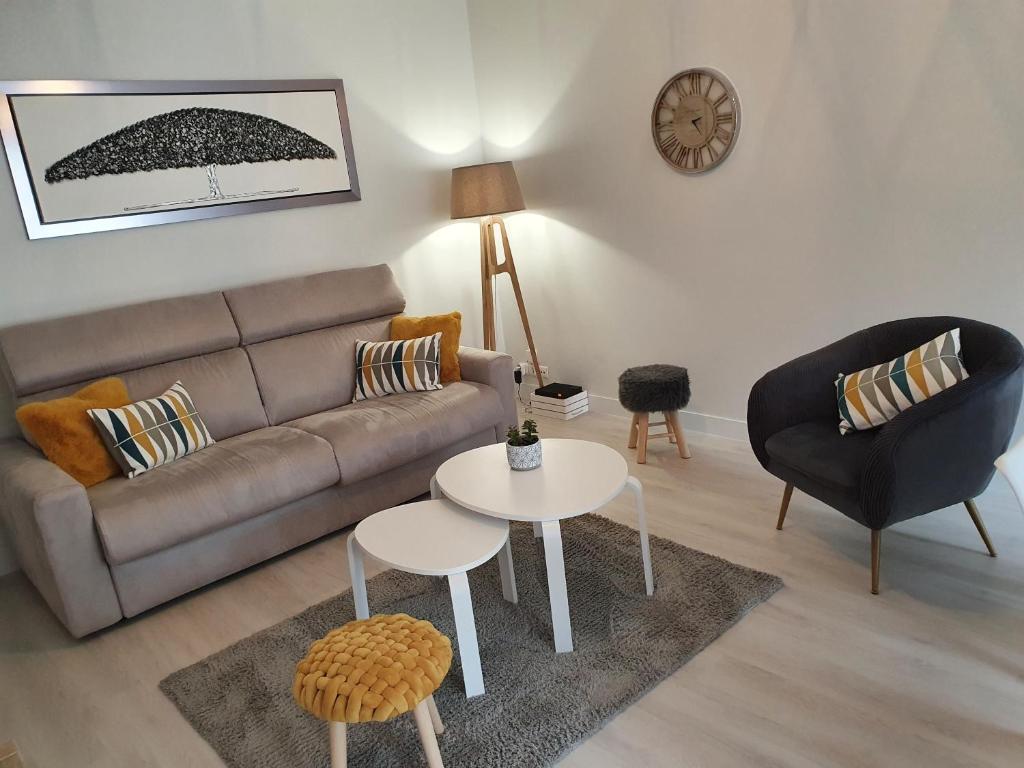 a living room with a couch and a table at Magnifique appartement avec garage privé et terrasse in Reims