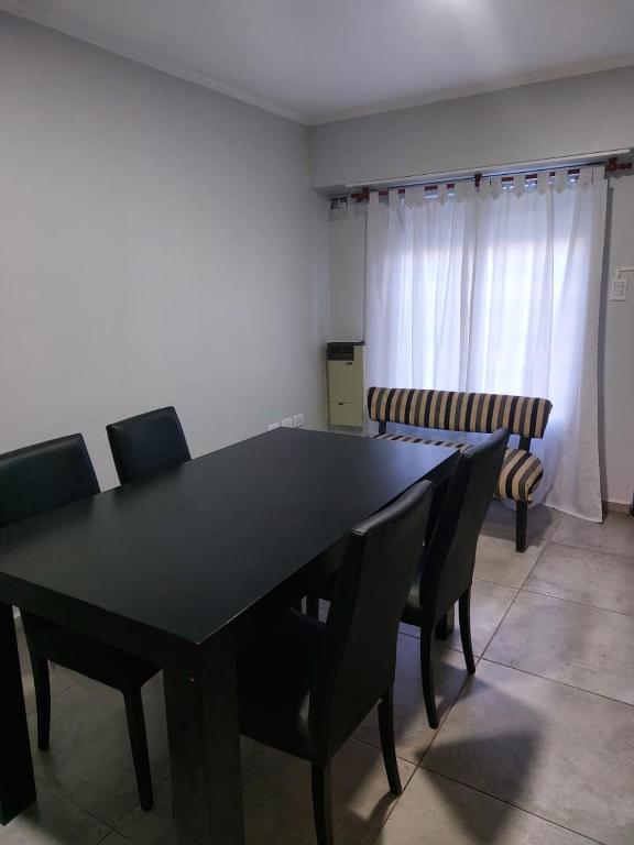 uma sala de jantar com uma mesa preta e cadeiras em Departamento de Caro em Tandil