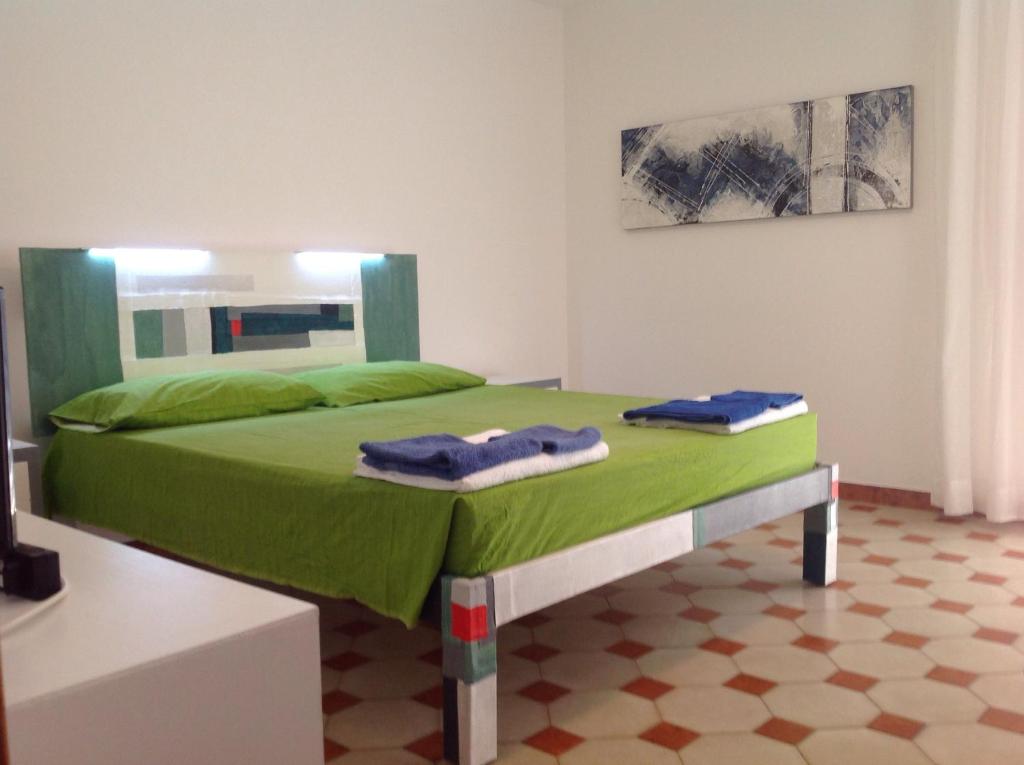 ラーカレにあるCasa Manni Torre Sudaのベッドルーム1室(緑のベッド1台、タオル2枚付)