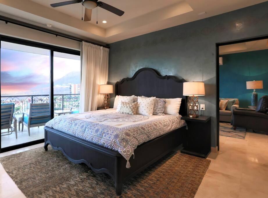 a bedroom with a large bed and a balcony at Stunning 3BR Condo with Ocean Views, Golf Course & Resort Amenities in Cabo San Lucas