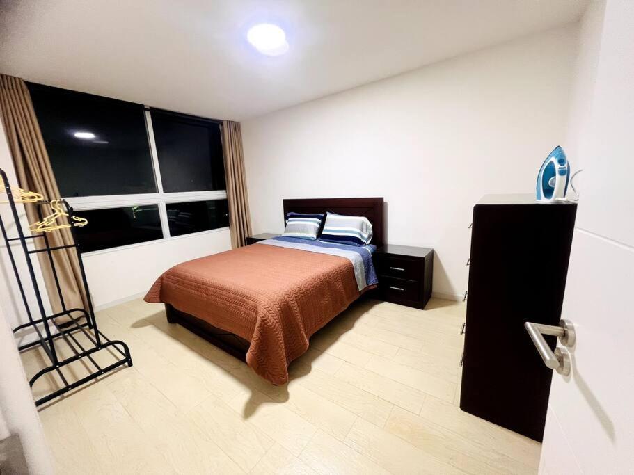 1 dormitorio con cama y ventana en Departamento 2do y 3er anillo en Santa Cruz de la Sierra