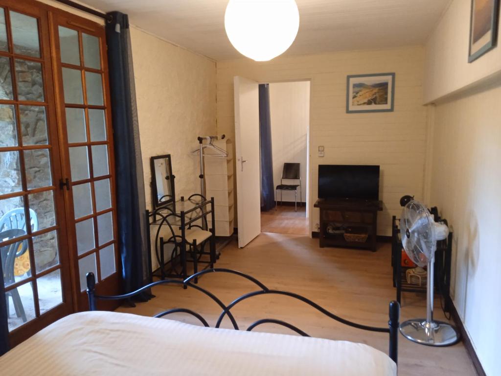 ein Schlafzimmer mit einem Bett und einem TV in einem Zimmer in der Unterkunft Chambres d'hôtes du Péras in Saint-Jean-du-Gard