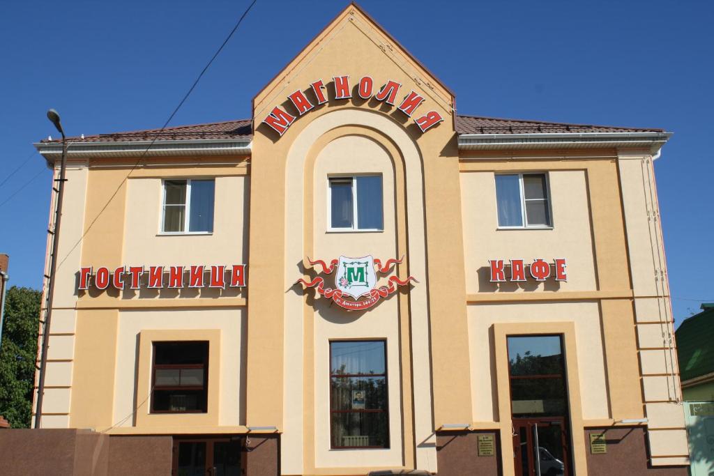 un bâtiment avec un panneau indiquant un hôtel dans l'établissement Hotel Magnoliya, à Rostov-sur-le-Don