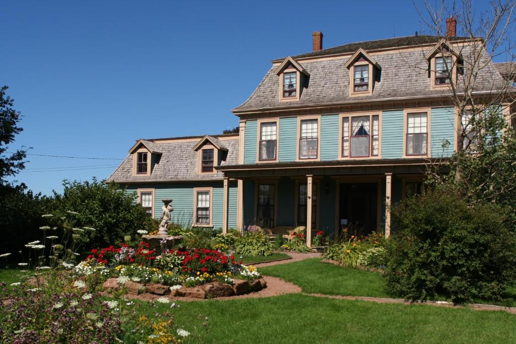 uma casa antiga com um jardim em frente em Barachois Inn em Rustico