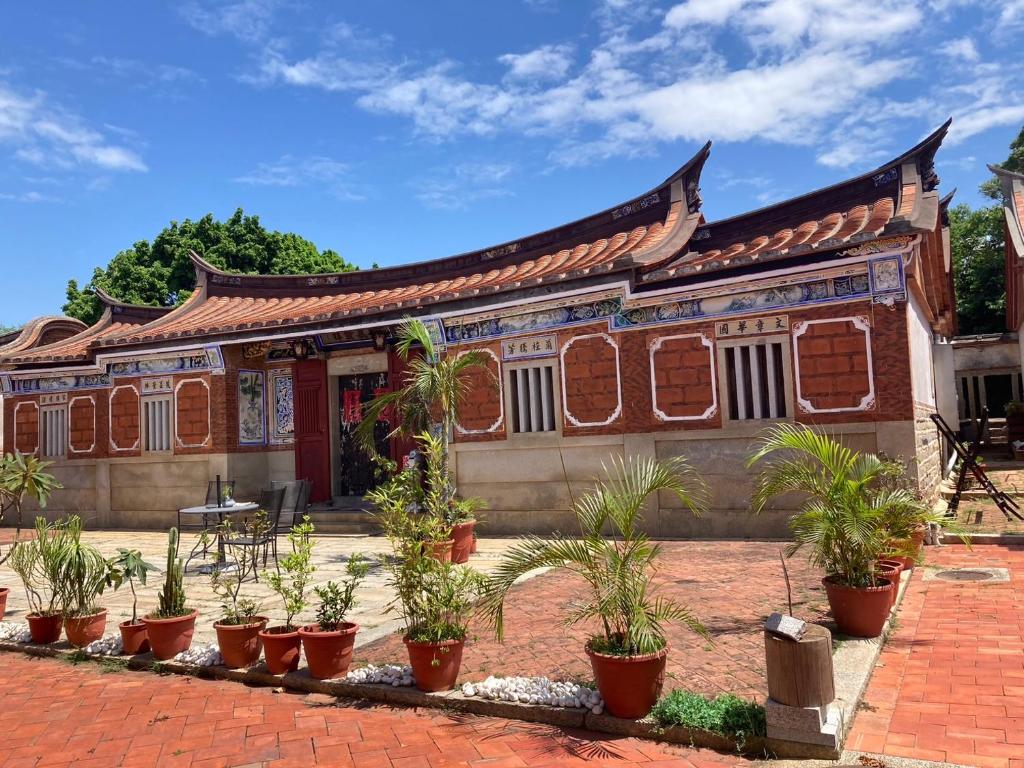 a building with potted plants in front of it at Shenten Homestay in Jincheng