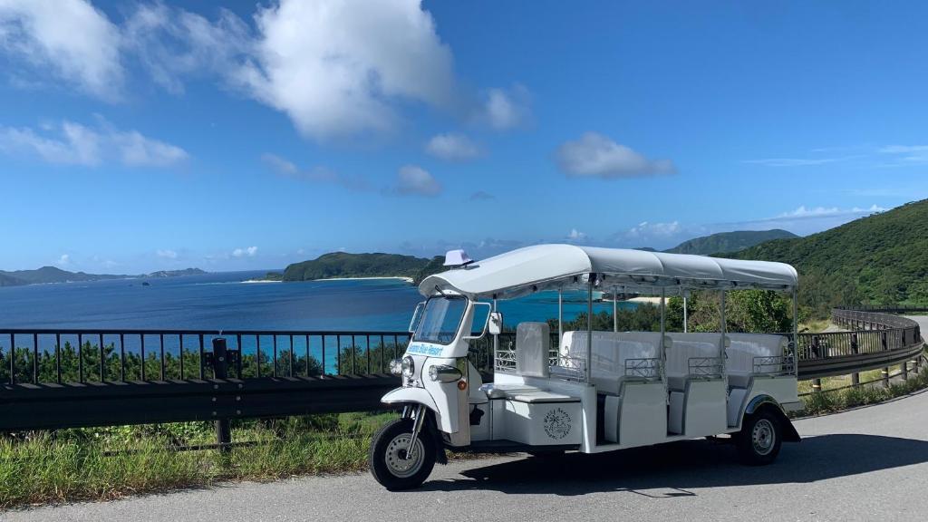 a white golf cart parked on the side of a road at Kerama Blue Resort in Zamami