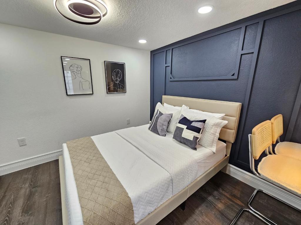 een slaapkamer met een groot bed met een blauw hoofdeinde bij The Hideaway DT Orlando Tiny Home w Free Parking in Orlando
