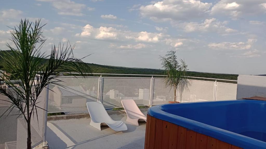 a balcony with two white chairs and a blue tub at Villa sol in Cordoba