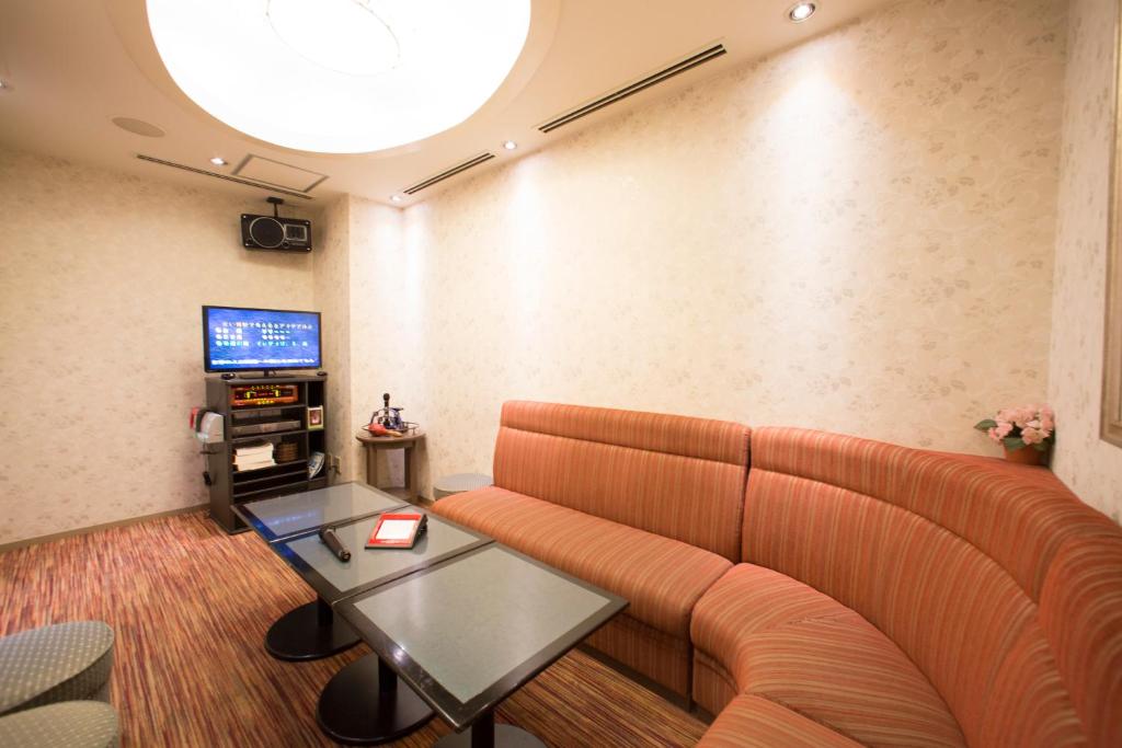 un soggiorno con divano, tavolo e TV di Hotel Resorpia Atami ad Atami