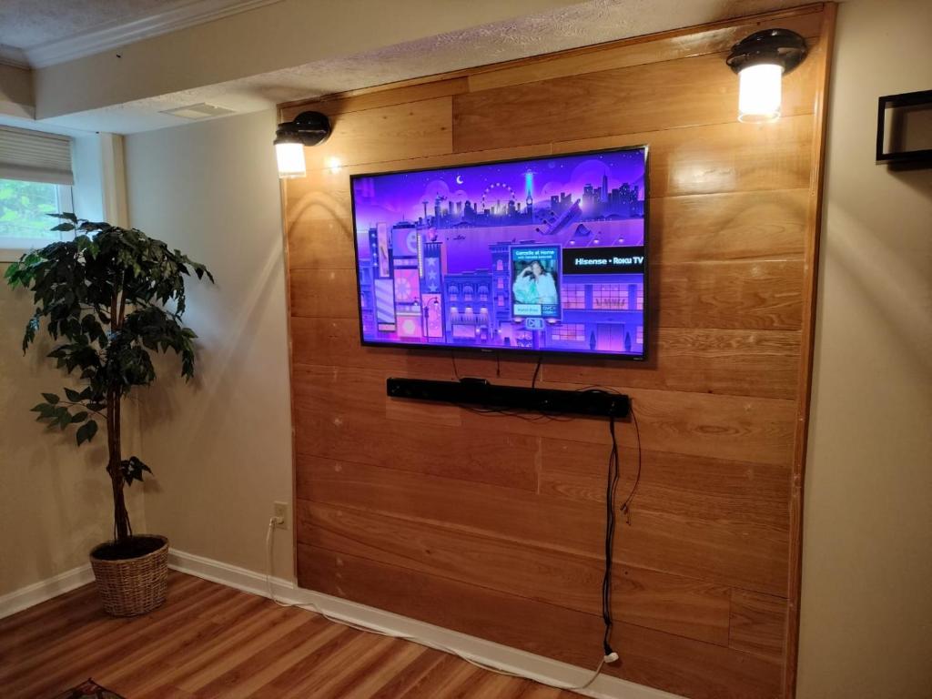 een woonkamer met een flatscreen-tv aan de muur bij Luxury Basement Apartment LA CASA in Winchester