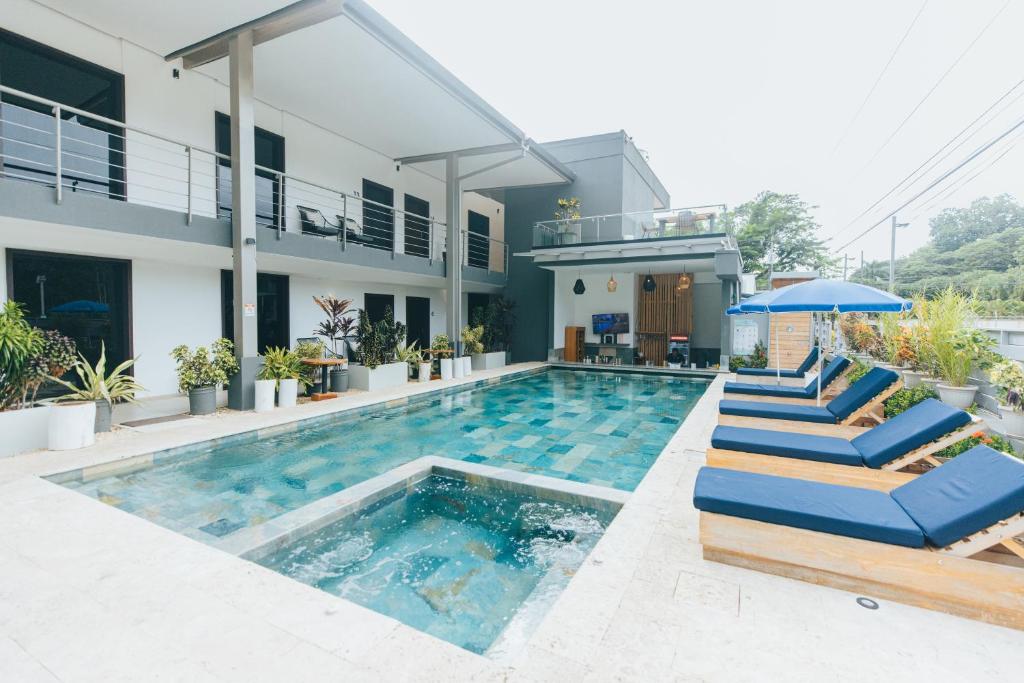 una casa con una piscina con tumbonas azules en Paradise Bay Hotel Boutique en Herradura