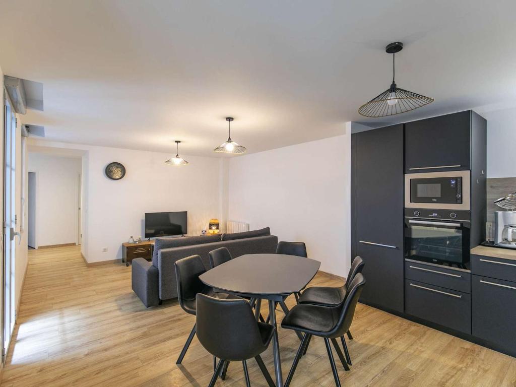 cocina y sala de estar con mesa y sillas. en Appartement Cauterets, 3 pièces, 8 personnes - FR-1-401-266, en Cauterets