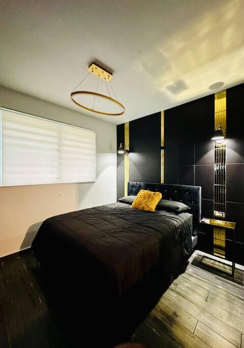 Un dormitorio con una cama negra y una lámpara en Pasavento - Modern Tiny Suite, en Aguadilla