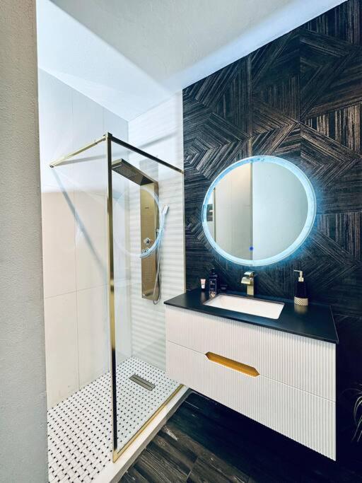 un baño con lavabo y espejo en Pasavento - Modern Tiny Suite, en Aguadilla