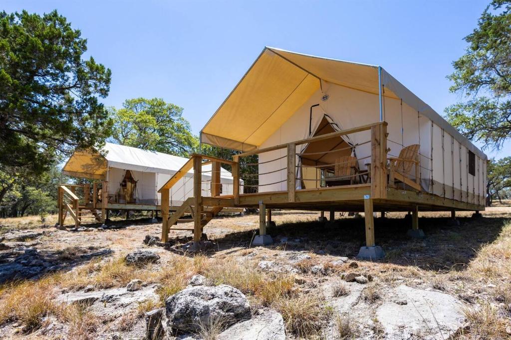 a large building with a tent in a field at Twin Falls Luxury Glamping - Stargazer in Boerne