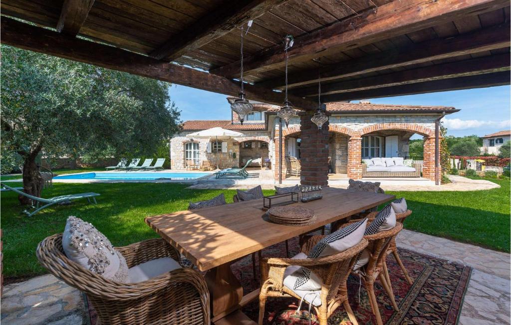 Une table et des chaises en bois sont disponibles sur la terrasse. dans l'établissement Villa Novel, à Višnjan