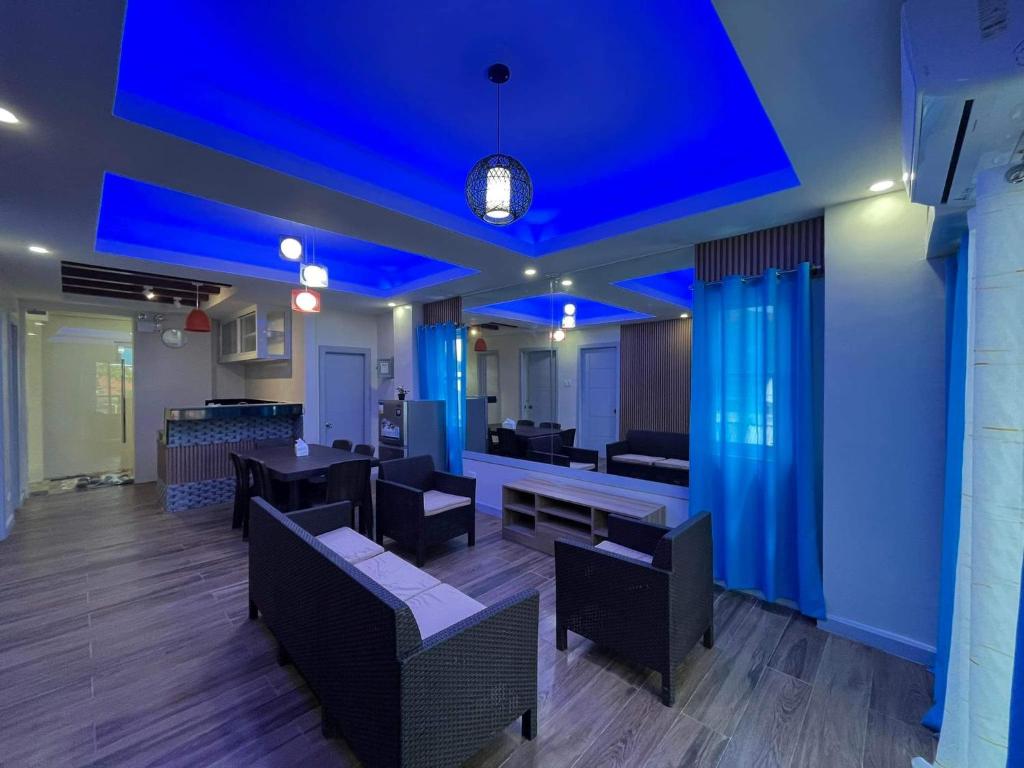 a dining room with blue lights on the ceiling at Baron & Pedra's Residence in General Luna