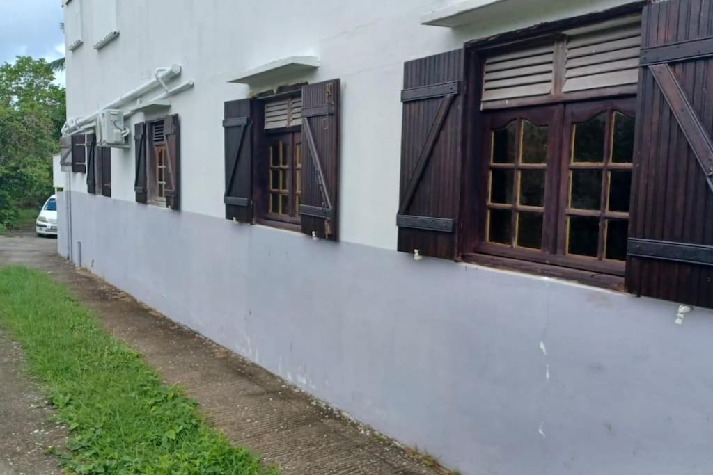 a row of windows on a white building at Charmant logement à 6min en voiture de la plage. in Anse-Bertrand