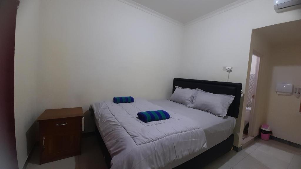 um quarto com uma cama com duas almofadas em Homestay morelia em Labuan Bajo