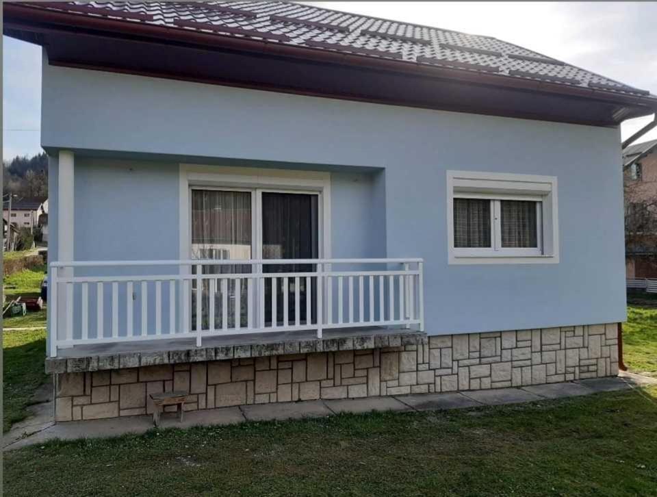 a small white house with a balcony at HOLIDAY HOUSE MARIC 