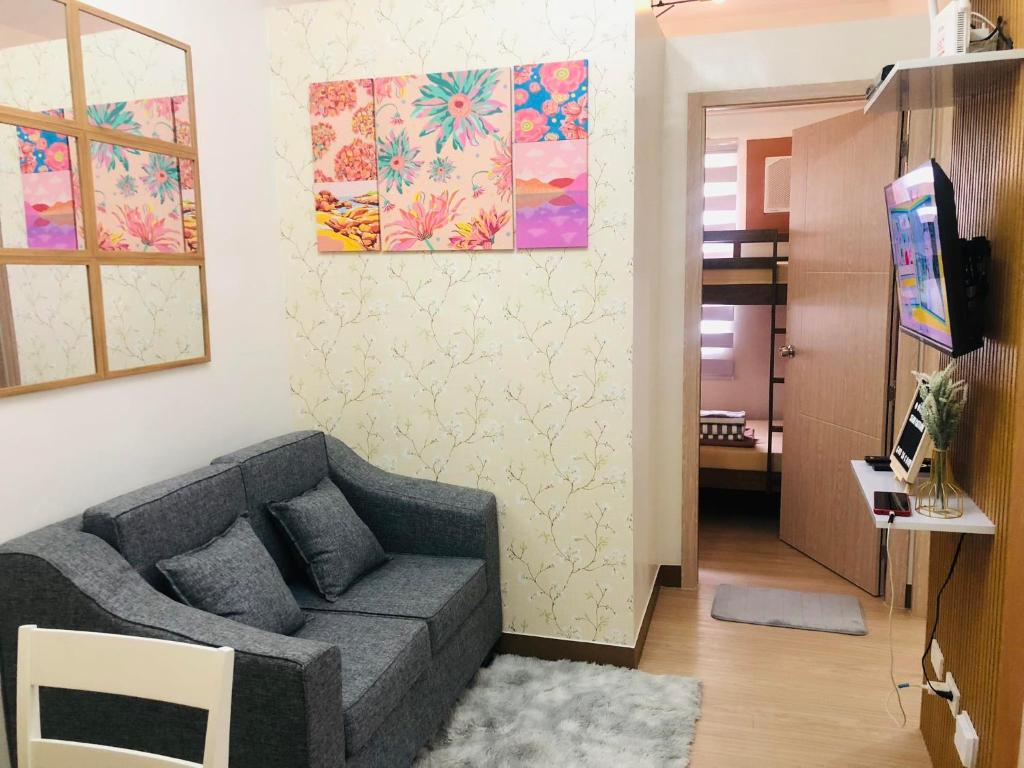 sala de estar con sofá y TV en Osam Empire Suites 2BR Staycation at Trees Residences Condominium, en Manila