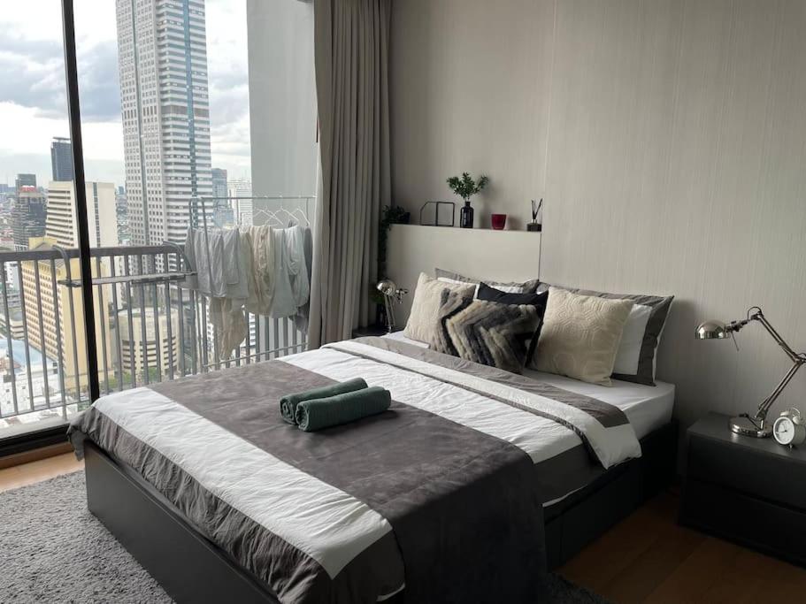 a bedroom with a large bed with a large window at Private room with 1 Bedroom & 1 Bathroom, near BTS Surasak in Bangkok